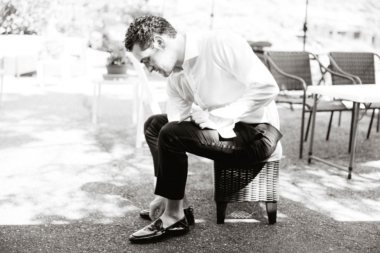 A black and white photo sequence showing someone sitting down and crossing their legs in four progressive steps.