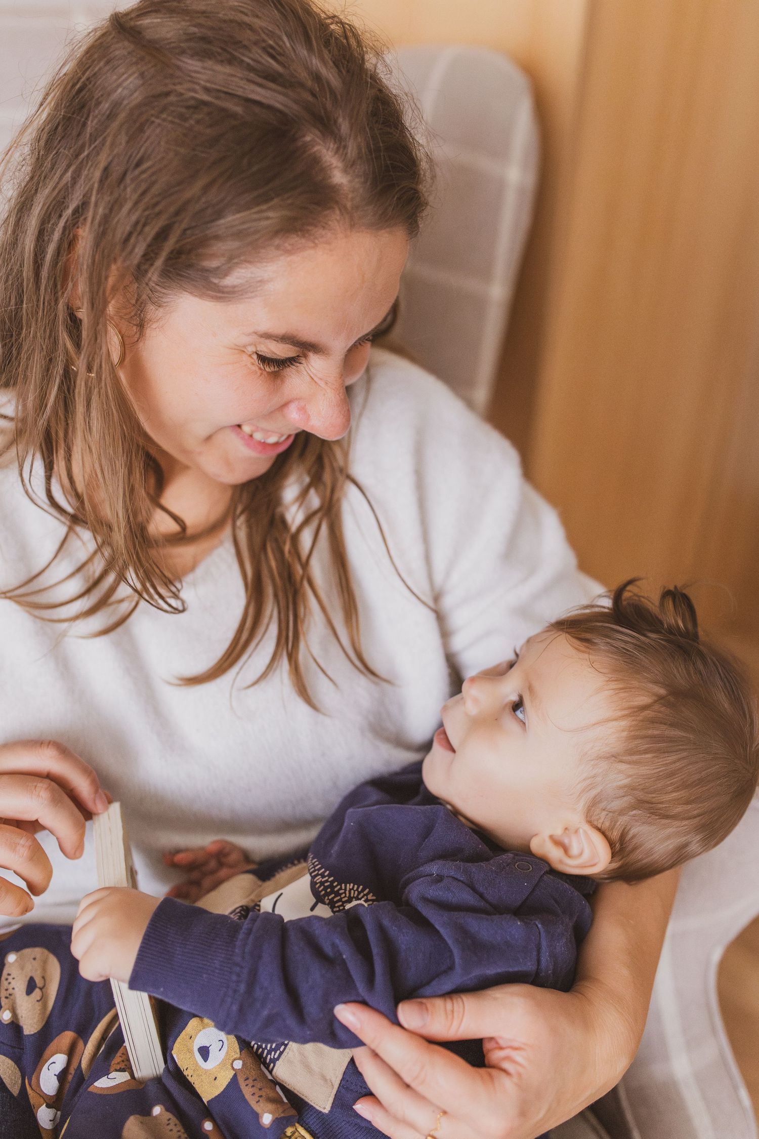 Foto einer Familien Homestory, zeigt Kind in Superheldenkostüm das sich auf ein Handtuch legt um von Eltern geschaukelt zu werden.