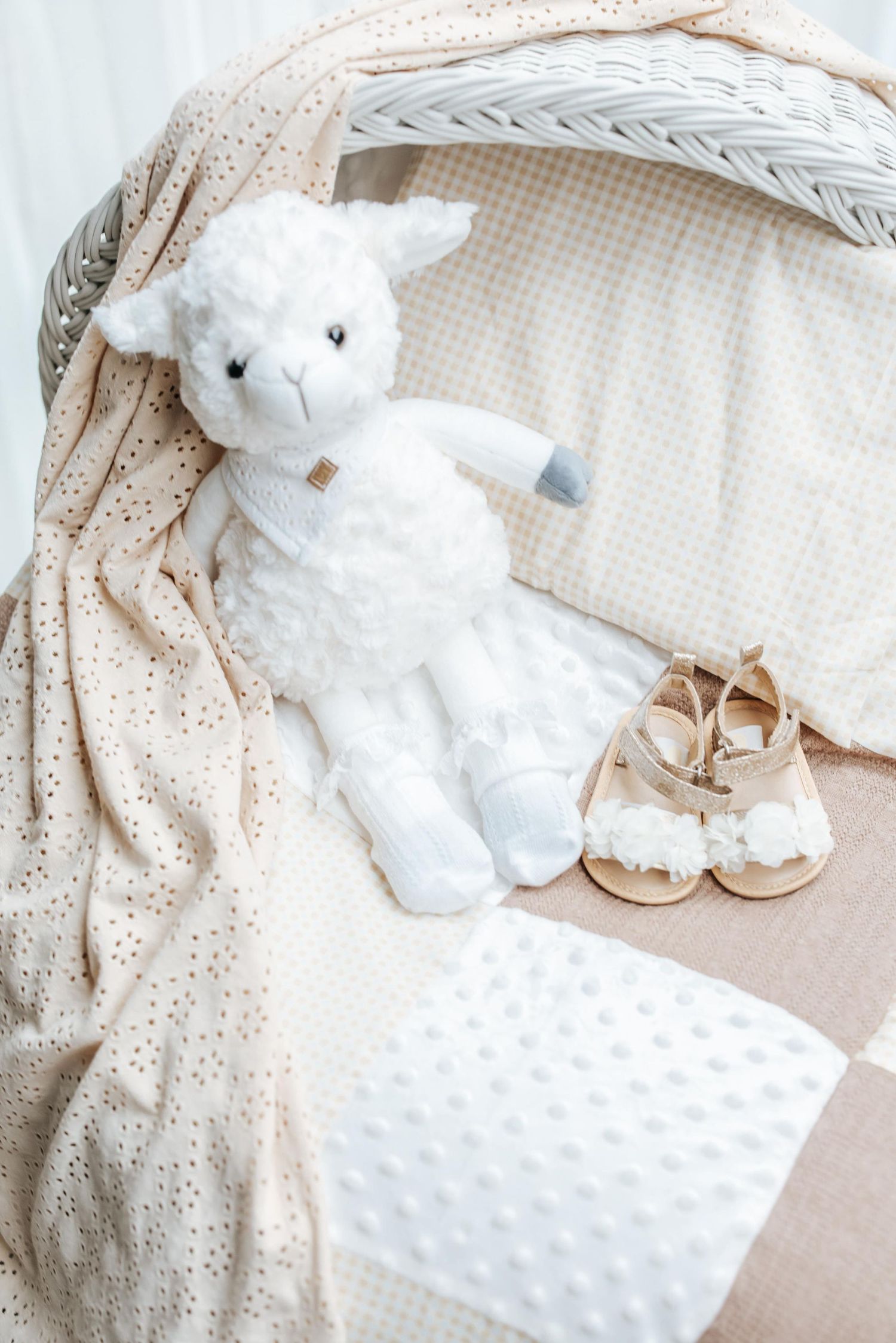 White plush teddy bear and minky blanket set arranged on cream colored textured bedding.