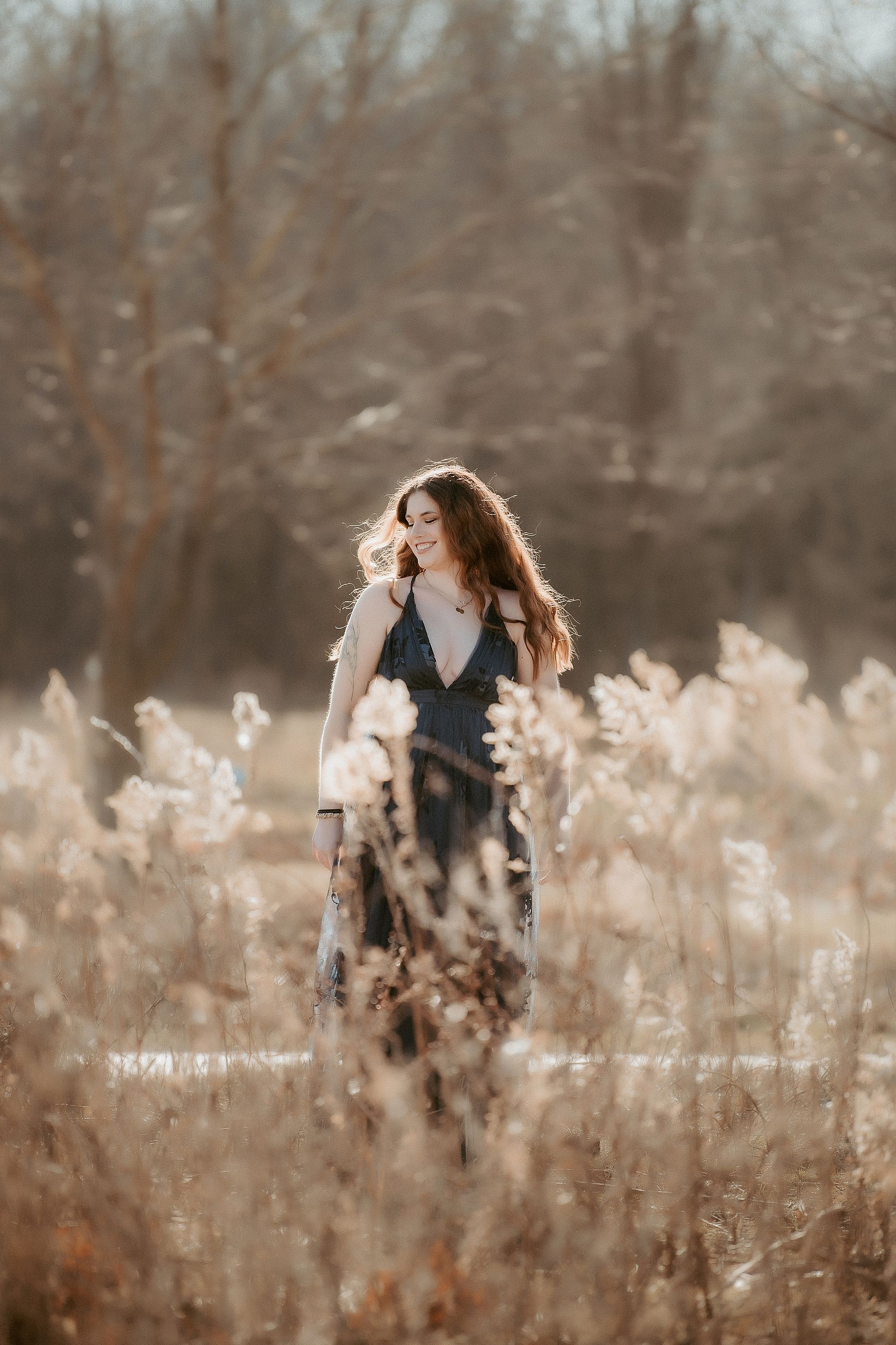 A couple embraces in a romantic moment among tall dried pampas grass during a golden hour outdoor photoshoot.