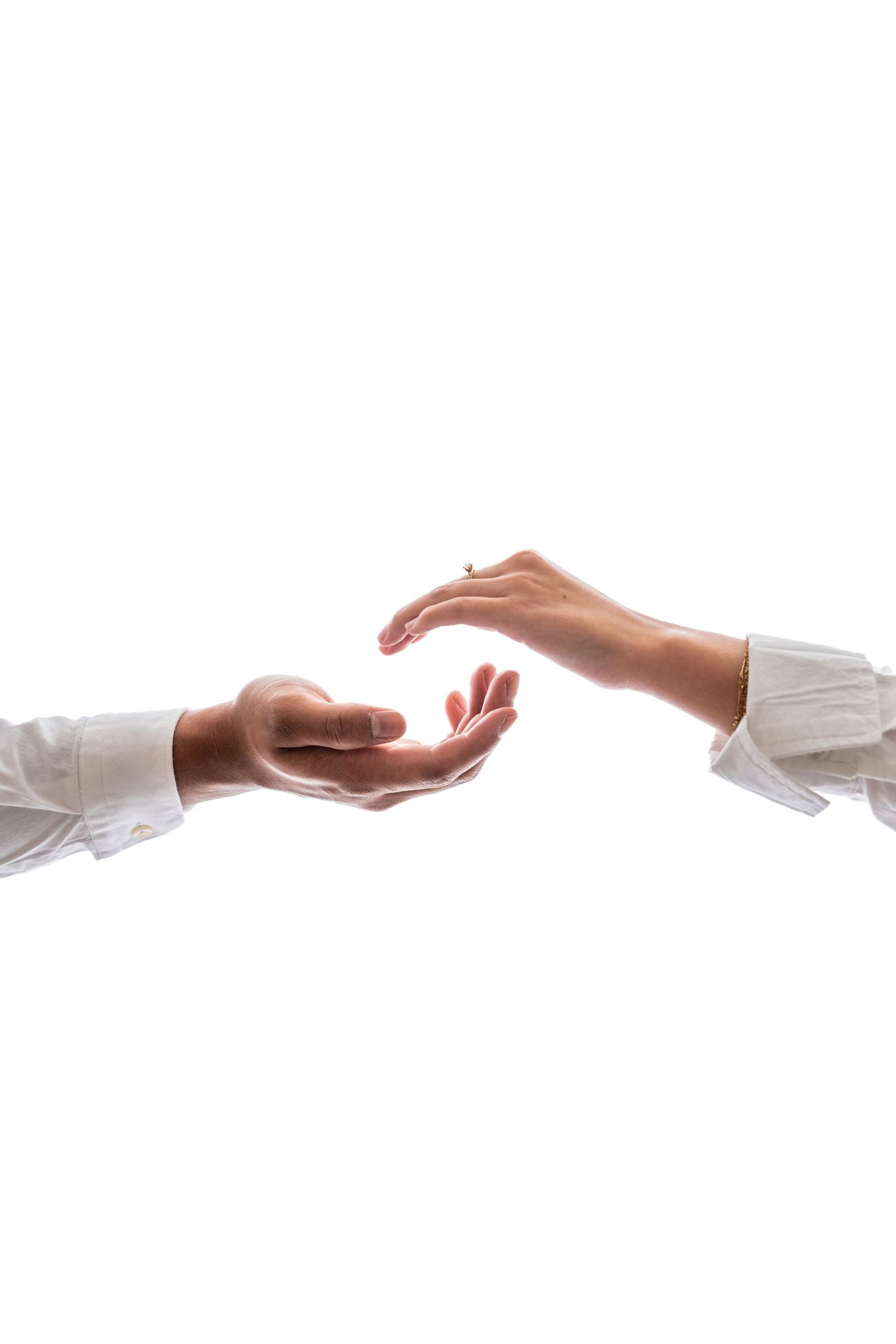 Two hands reaching toward each other against white background in an artistic gesture.