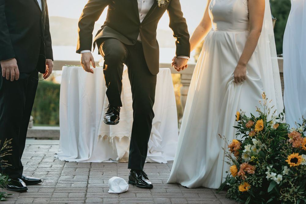 A close-up shot of formal attire and floral decorations during an outdoor wedding ceremony.