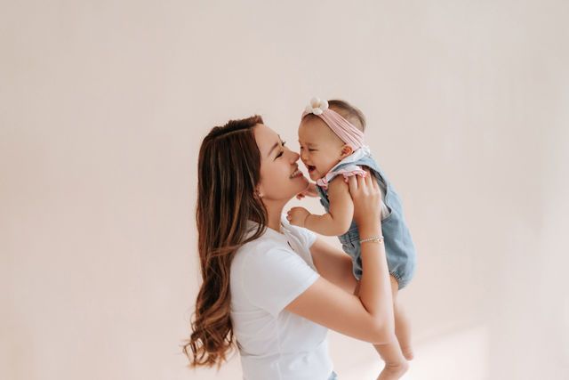 A series of tender moments between parent and baby shown in soft, warm lighting against neutral backgrounds.一系列父母與嬰兒之間溫馨的瞬間，在柔和溫暖的燈光和中性背景的襯托