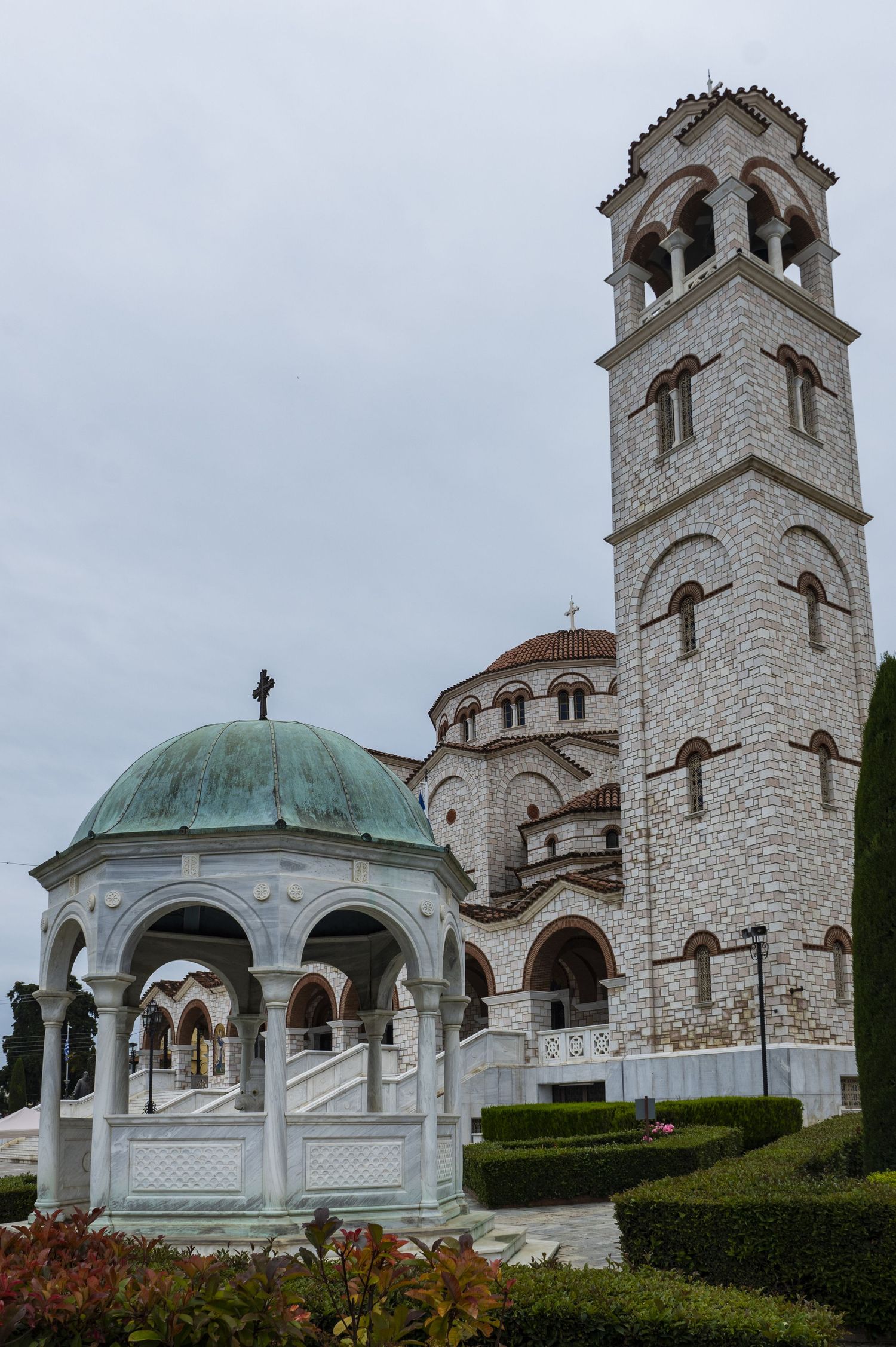 White stone church with bell tower and blue domed mausoleum sits on landscaped hillside in Mount Stuart, Washington.