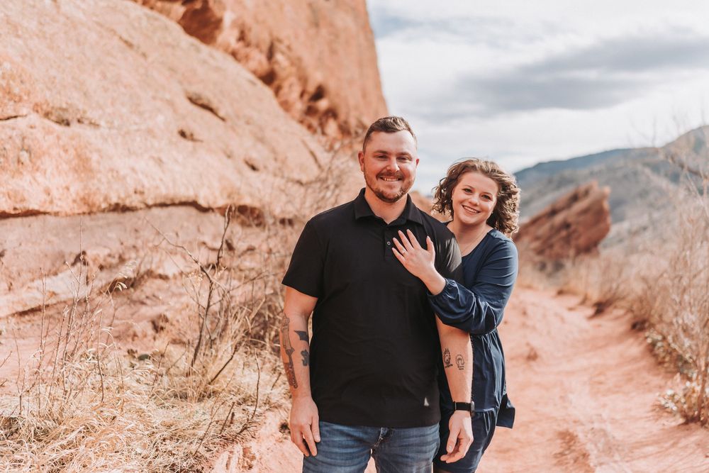 A couple explores the scenic red rock formations at Garden of the Gods in Colorado during golden hour.
