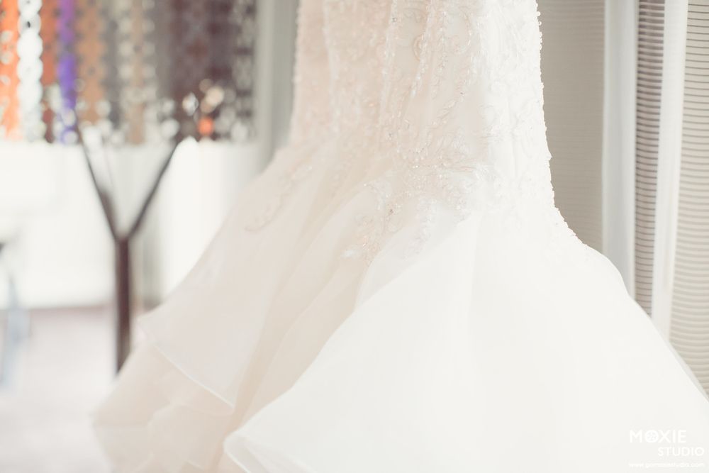 A white sheer curtain panel billows gently in front of a bright window with natural daylight streaming through.