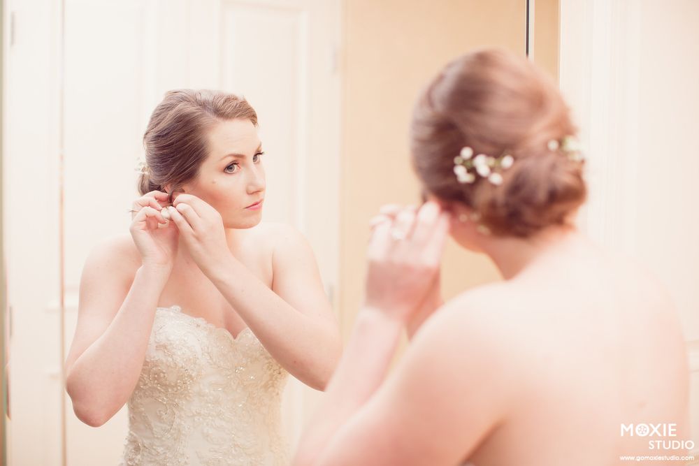A bride in a white wedding dress gets ready with soft pink lighting and romantic atmosphere.