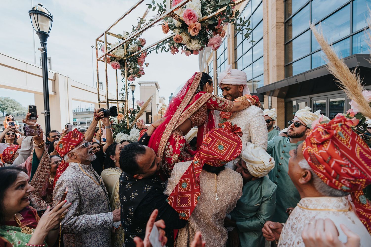 Memory Lane Studios vibrant outdoor Indian wedding celebration with bride in traditional red and gold attire by photographer Tharun Palla