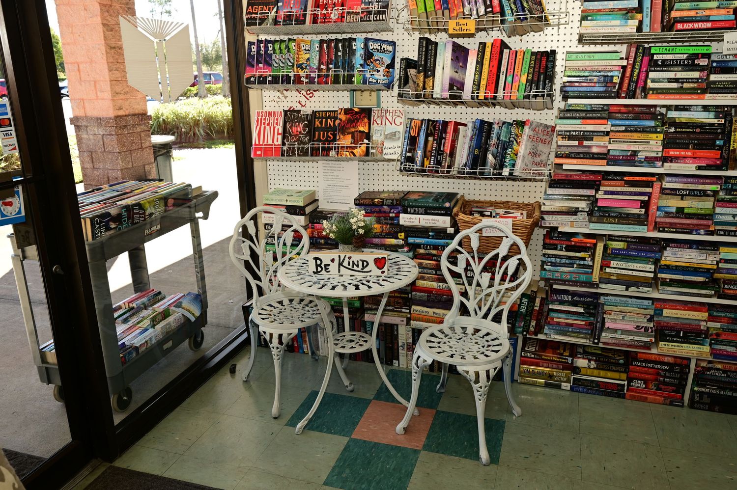 Wide view of a bookstore interior showing multiple book displays and seating areas.