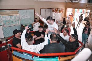 Group of people celebrating enthusiastically at what appears to be a corporate event.