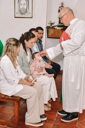 A religious blessing or baptism ceremony taking place in a traditional church setting.