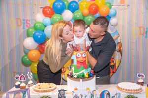 Festive birthday party setup with colorful balloon arch and decorations.