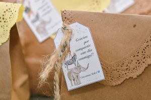 Decorative gift tag with unicorn illustration attached to kraft paper packaging.