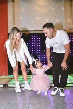 Family dancing together on a lit-up dance floor during a celebration.