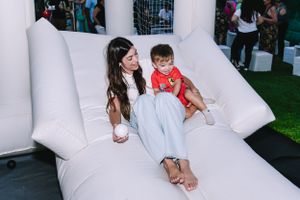 Two people relaxing on a large white inflatable couch at an outdoor event.