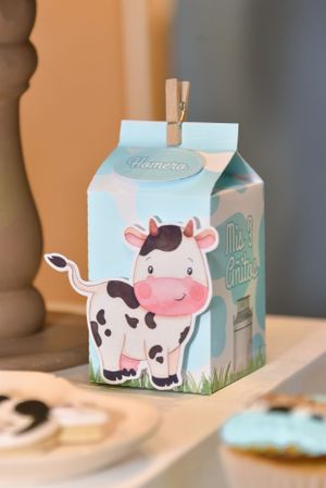 Cute milk carton favor box decorated with cartoon cow design and clothespin.