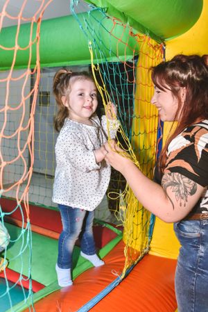 Indoor playground scene with climbing nets and bright neon colors.