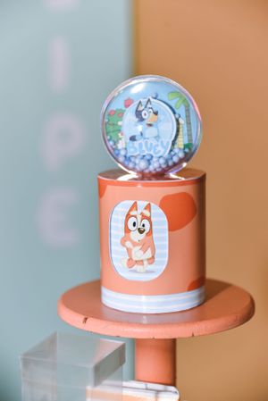 Decorative snow globe featuring cute animal characters on coral-colored display stand.