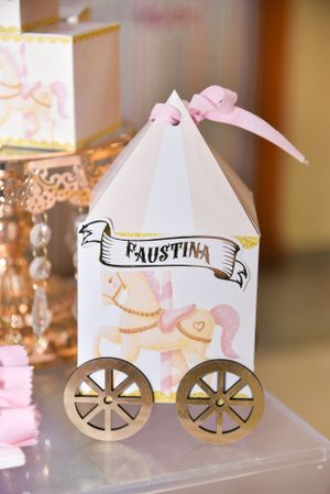 Decorative paper carriage name card holders with pink and gold accents.