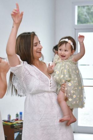 People dancing and celebrating in a bright indoor space wearing white outfits.