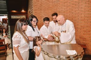 People gathered around a table watching a chef demonstrate cooking techniques in a brick-walled restaurant.