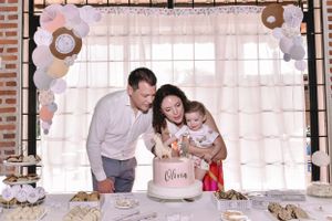 Birthday celebration setup with elegant balloon arch and white cake on display.