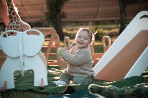 Garden party setting with decorative white furniture and plush animal toys.