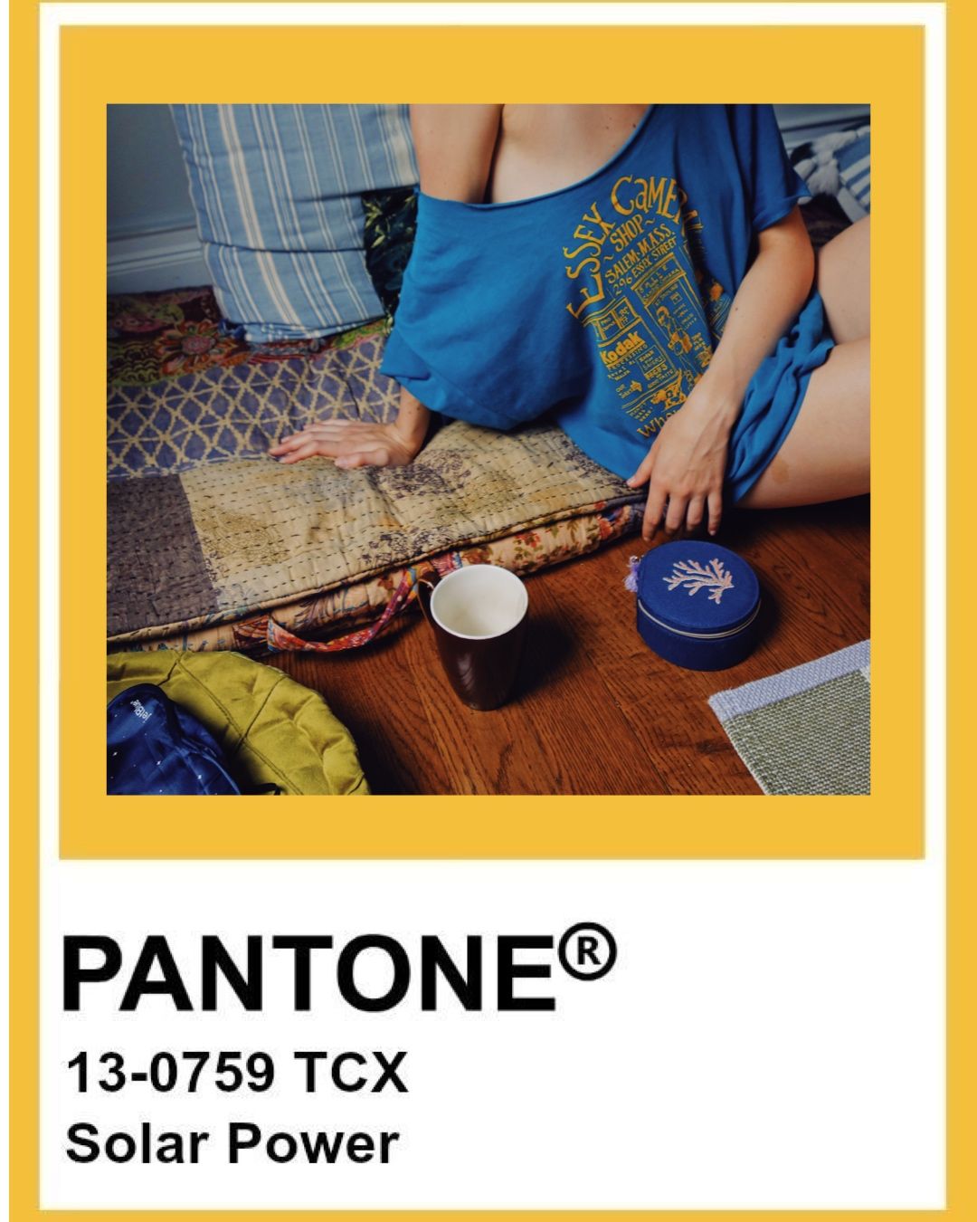 A person in blue clothing sits at a table with traditional tea ceremony items and a Pantone color swatch labeled Solar Power.
