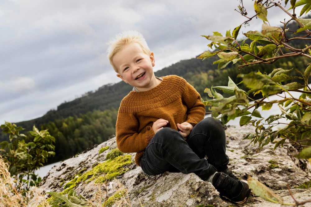 Gutt som sitter på svaberg på barnefoto i Mandal