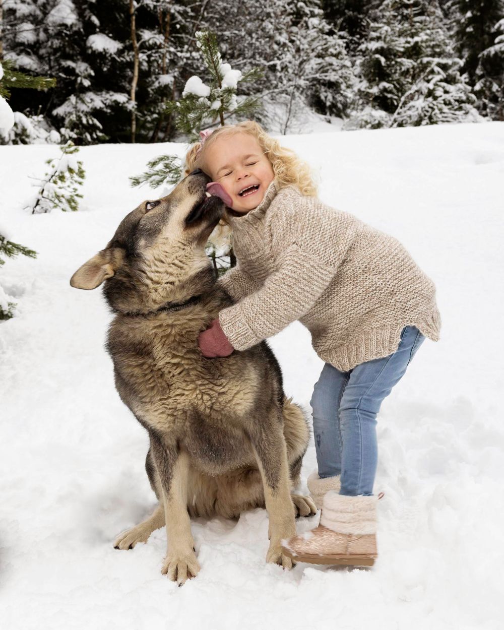 Jente som koser med hund og ler på barnefotografering i Mandal