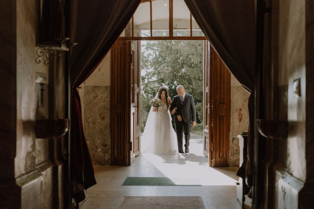 A couple entering through grand wooden church doors at their wedding ceremony.