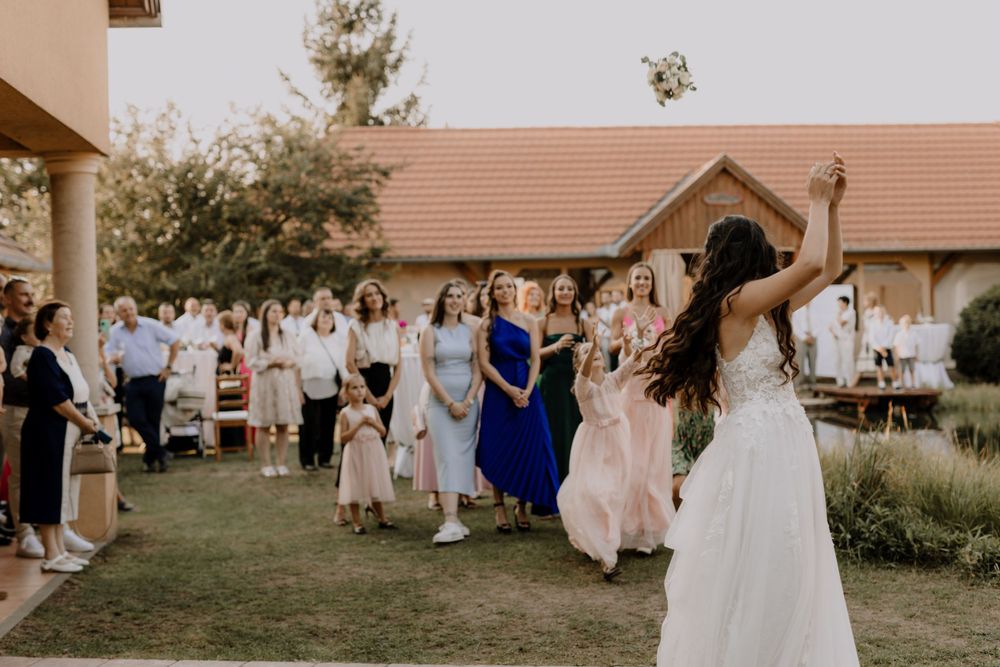 Wedding guests gather outdoors to celebrate during a daytime reception.