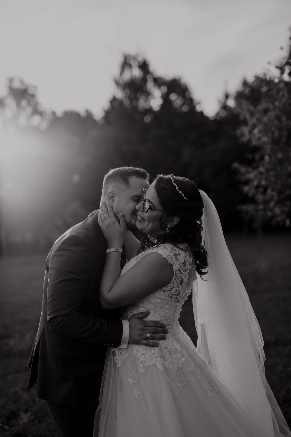 Romantic sunset portrait of newlyweds embracing outdoors.