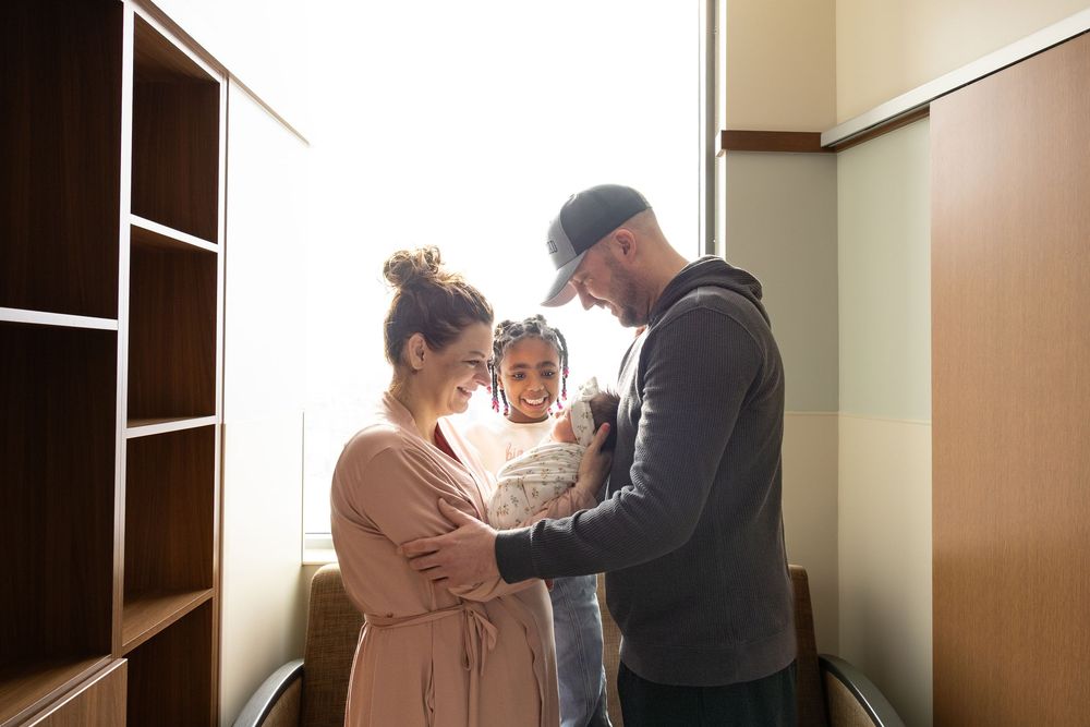 Happy family with mother, father, and baby sharing a tender moment together in a warmly lit room.