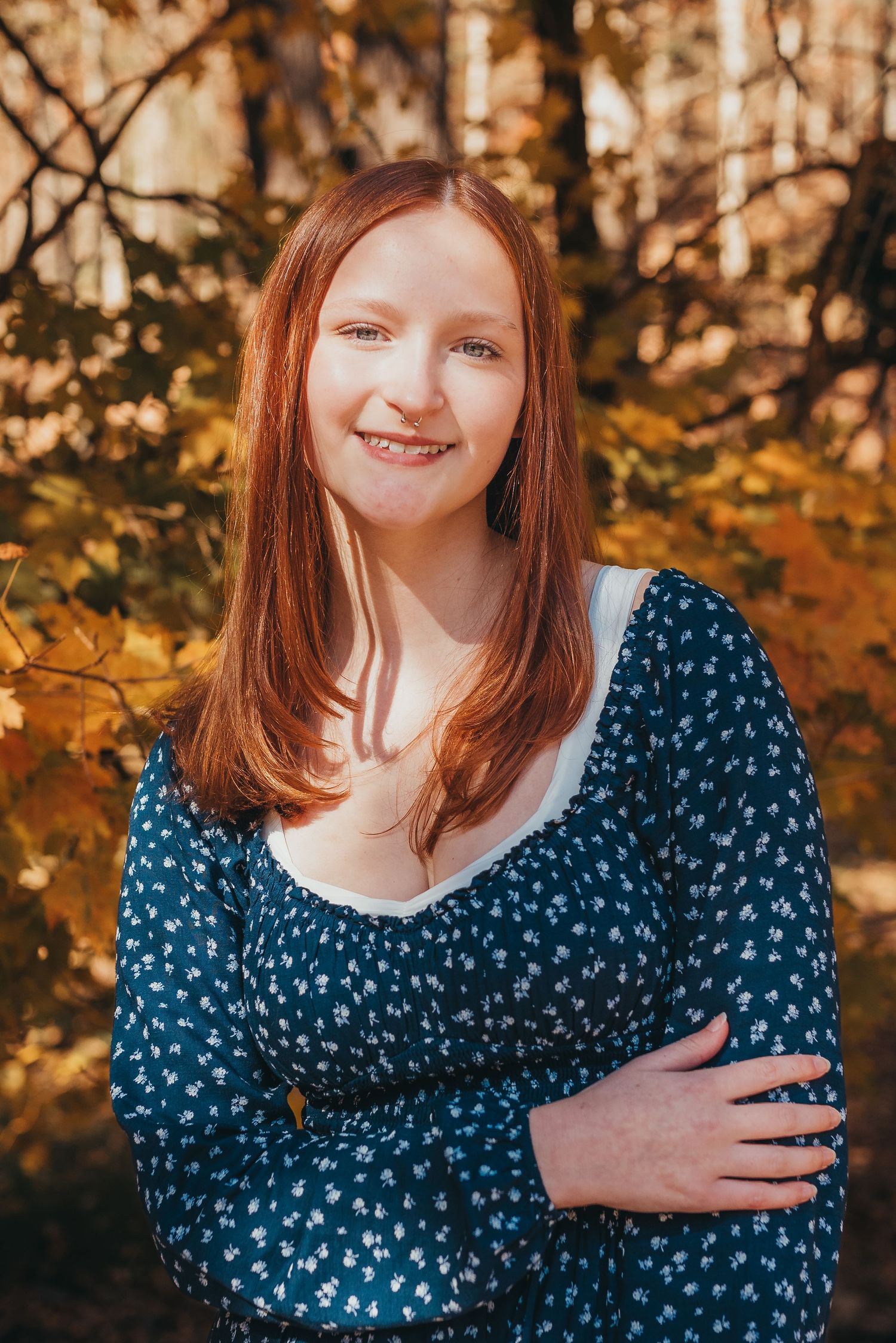 A warm autumn portrait with golden foliage in the background.