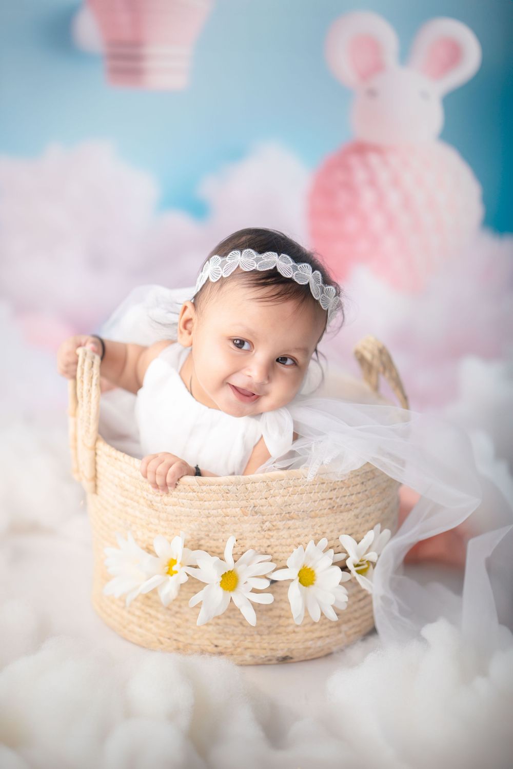 Newborn baby swaddled in cloth and placed in a wicker basket with warm lighting