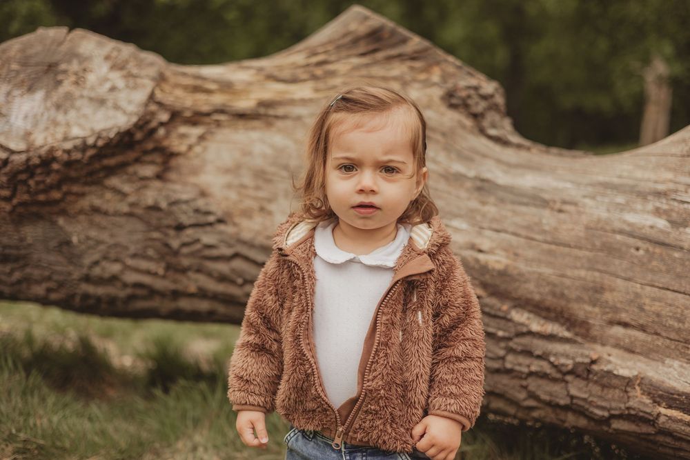 toddler standing in front of log on tooting common