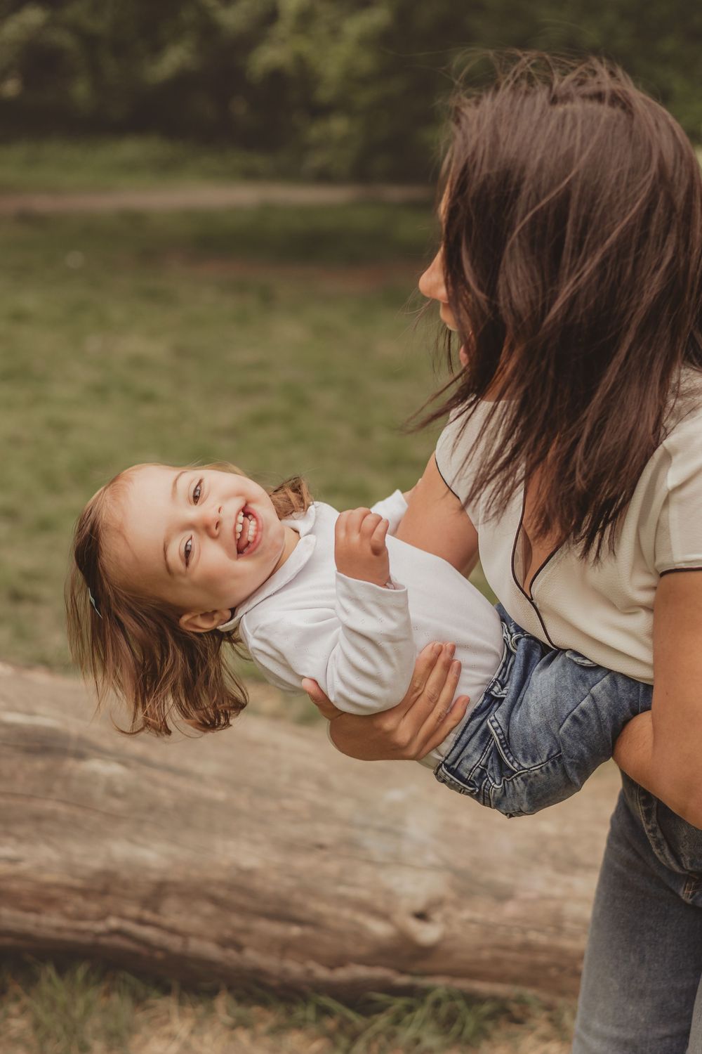 mum holding toddler and laughing, outdoors