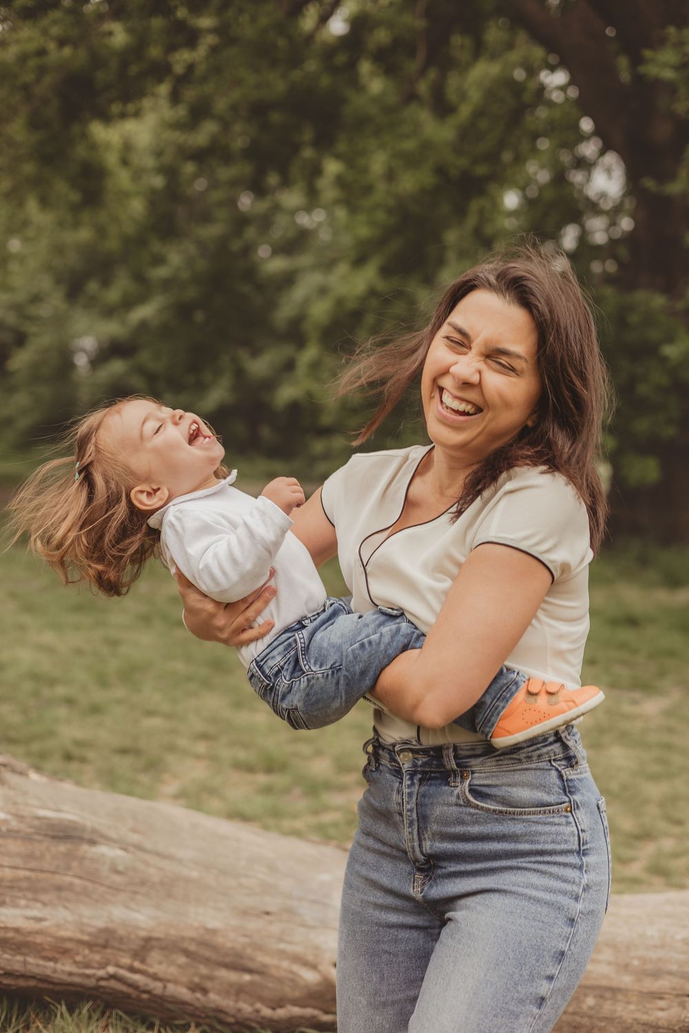 mum holding toddler and laughing, outdoors