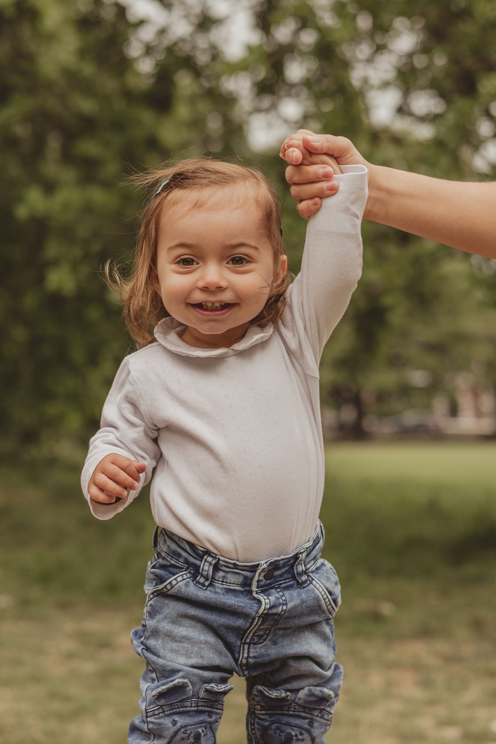 toddler wearing white top smiling at camera
