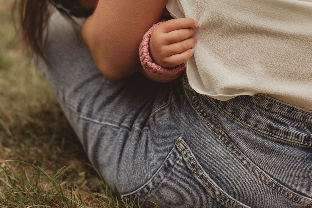 mum breastfeeding daughter outdoors