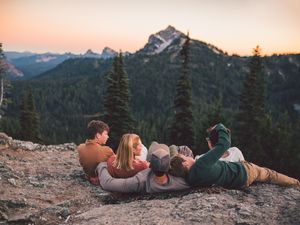 Family traveling to Mt. Rainier and sitting together during a family photoshoot in Mt. Rainier National Park in Washington
