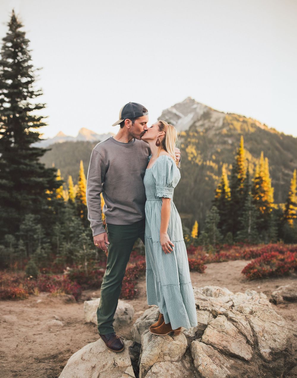 Couple hiking and traveling to Mt. Rainier and kissing together during a family photoshoot in Mt. Rainier National Park in Washington