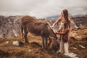 Sisters standing together at a mountains edge in the Dolomites Italy during their family adventure photoshoot