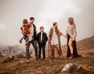 Family standing together at a mountains edge in the Dolomites Italy