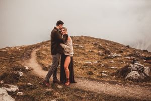 Couple standing together at a mountains edge in the Dolomites Italy during their family adventure photoshoot