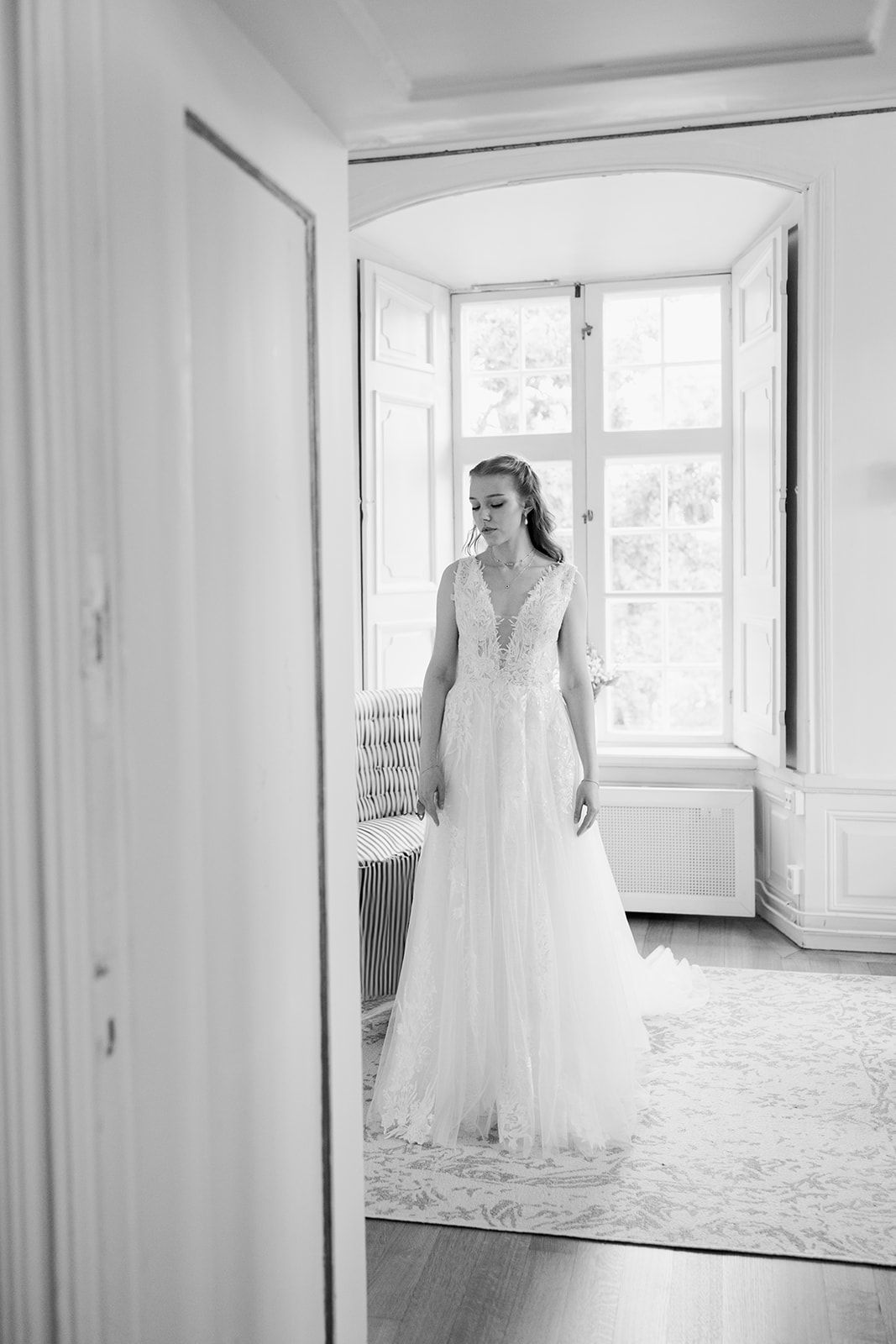 A series of elegant white wedding dresses displayed in bright, airy rooms with natural light streaming through windows.