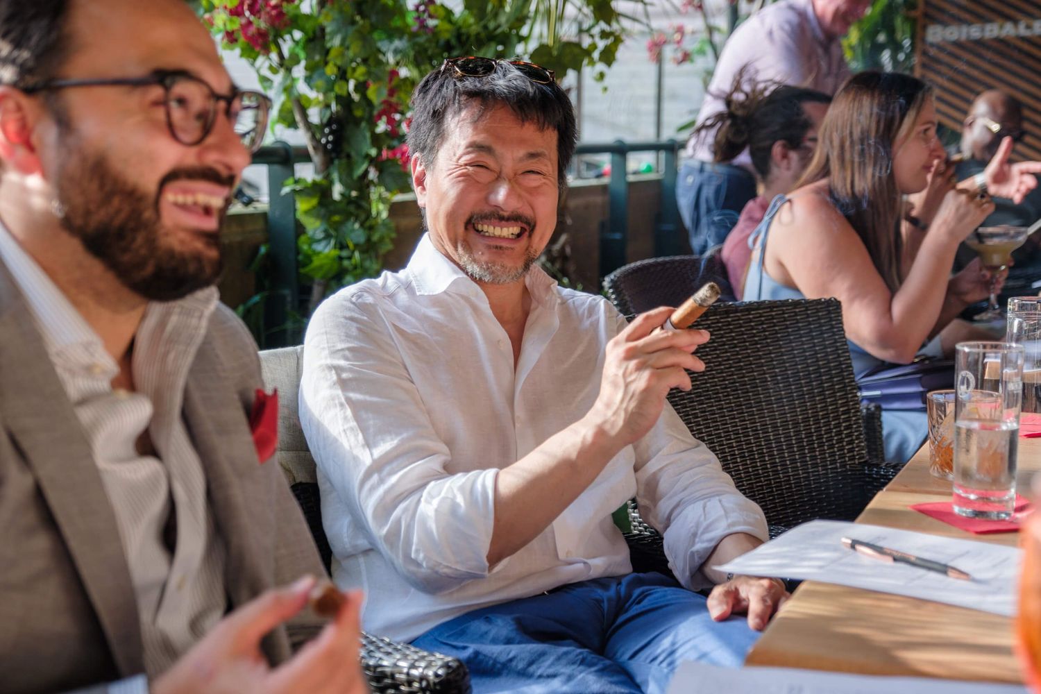 Group of friends enjoying a casual outdoor dining experience at a restaurant patio.
