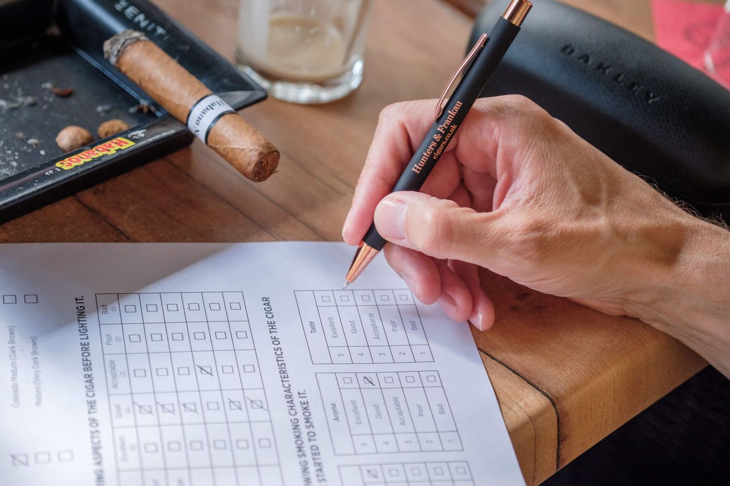 People working together on solving crossword puzzles at a table with papers and pens.