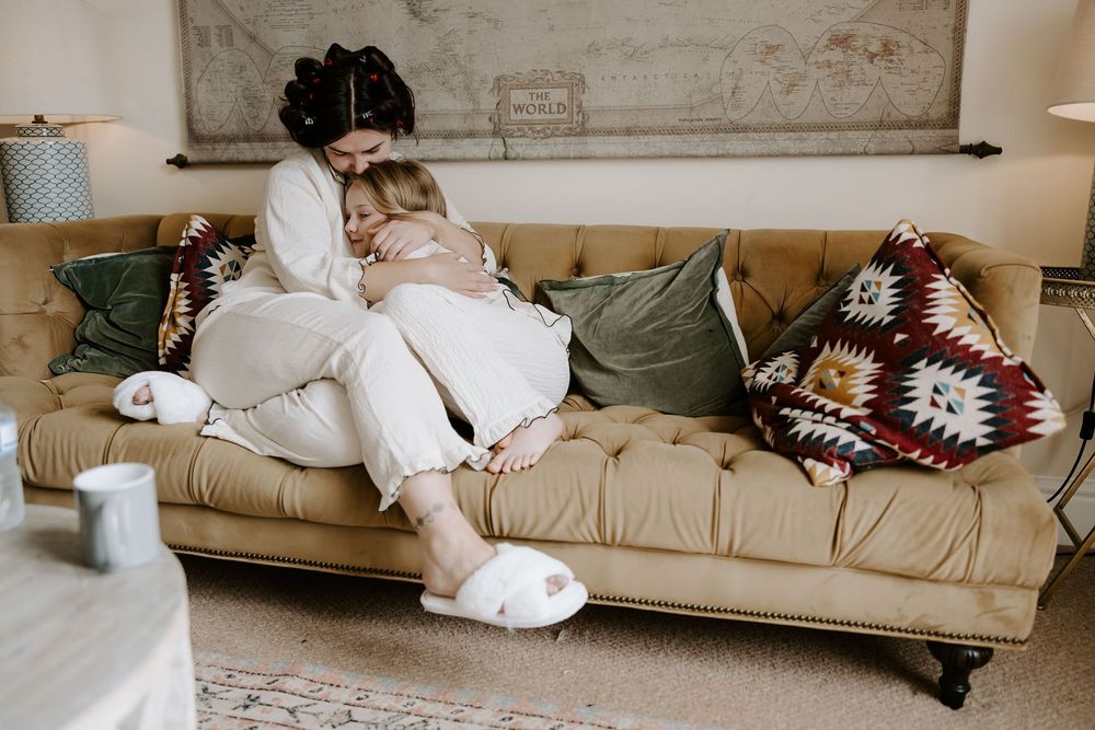 A cozy neutral living room interior with a beige tufted sofa and decorative throw pillows and blankets.